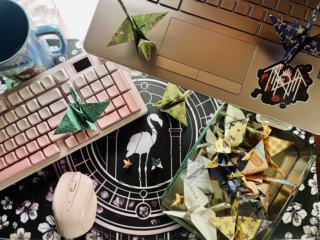 My author desk. 
Photo of paper cranes and Sleep Token desk mat.